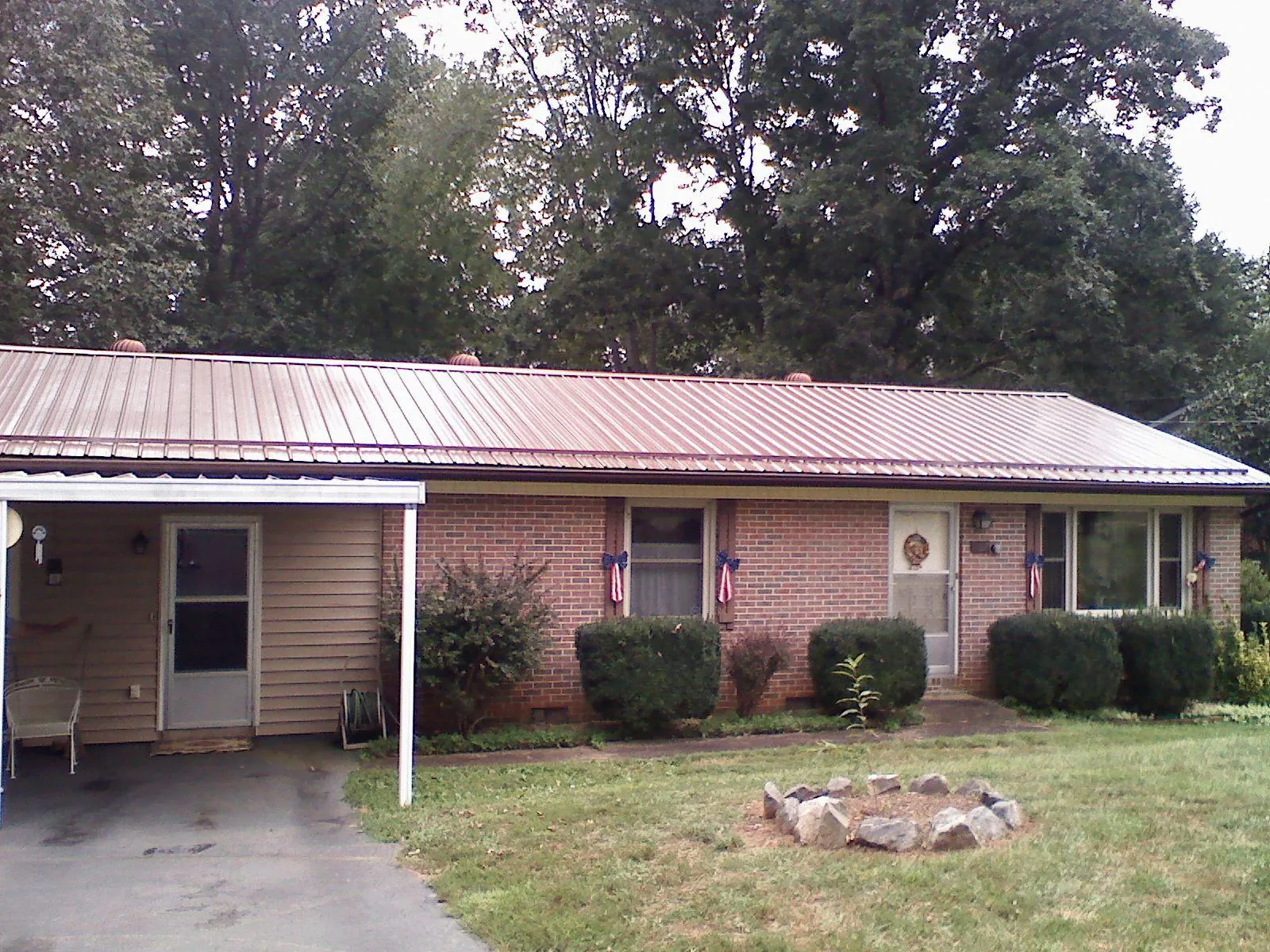 Bronze metal roof and carport on a brick ranch home — Roof Repair work by our crew in Adairsville